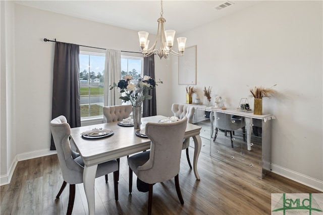 dining space with wood-type flooring and a notable chandelier