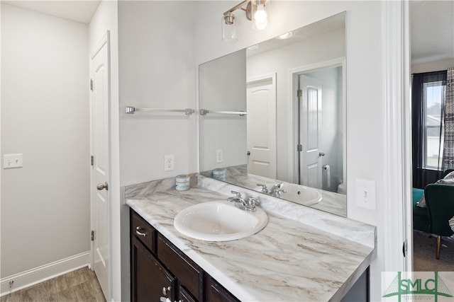 bathroom with vanity, wood-type flooring, and toilet