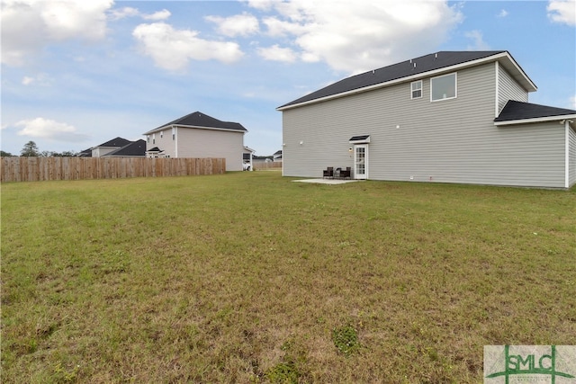 rear view of house with a lawn and a patio