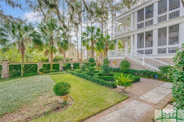 view of yard featuring ceiling fan and a balcony