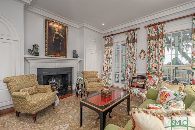 living room with hardwood / wood-style floors, ornamental molding, and a premium fireplace