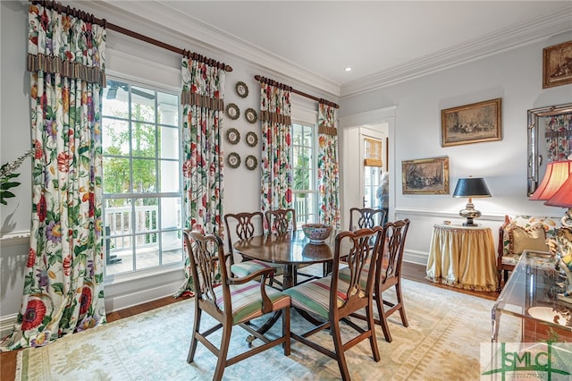 dining space with crown molding and light hardwood / wood-style flooring