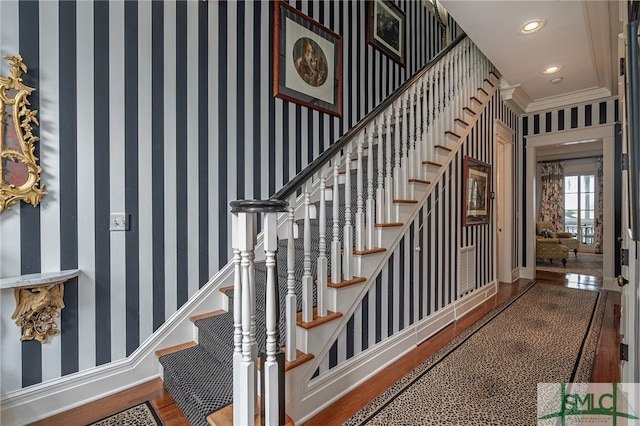 stairway with hardwood / wood-style floors and crown molding