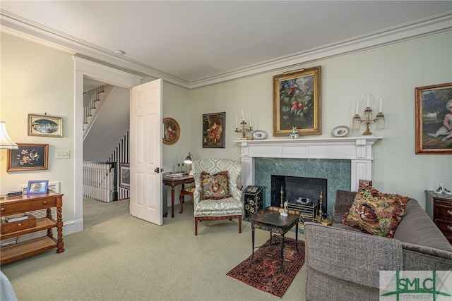 carpeted living room with a high end fireplace and ornamental molding