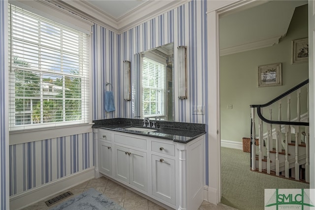 bathroom with a wealth of natural light, tile patterned flooring, vanity, and ornamental molding