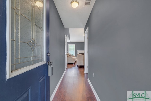 entryway with a textured ceiling, dark hardwood / wood-style floors, and lofted ceiling