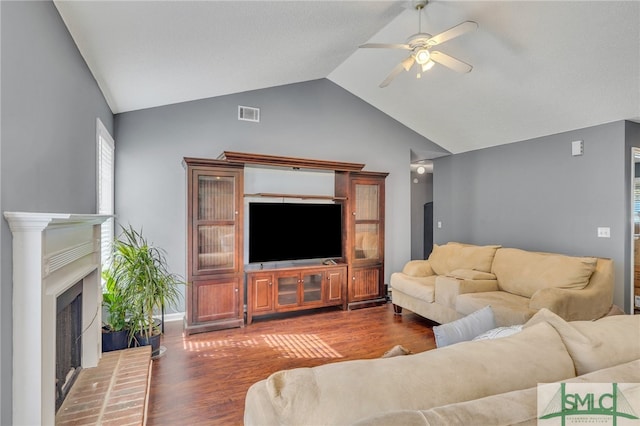 living room with ceiling fan, dark wood-type flooring, and vaulted ceiling