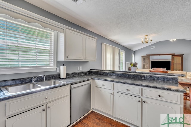 kitchen featuring white cabinets, dishwasher, lofted ceiling, and sink