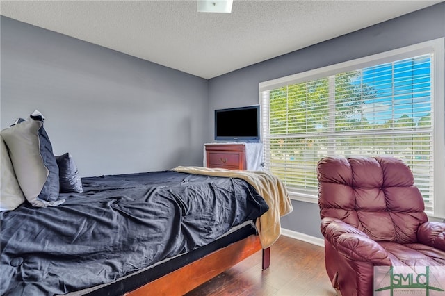 bedroom with dark wood-type flooring and a textured ceiling