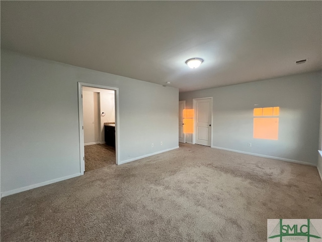 unfurnished bedroom featuring carpet flooring and connected bathroom