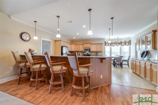 kitchen featuring appliances with stainless steel finishes, light hardwood / wood-style floors, and a spacious island