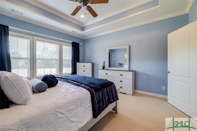 carpeted bedroom featuring a tray ceiling, ceiling fan, and ornamental molding