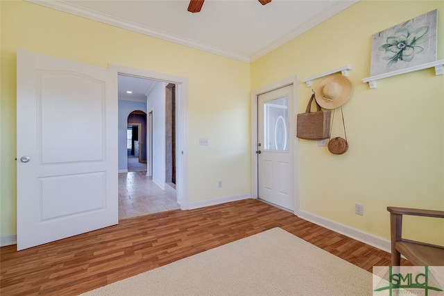 interior space featuring ceiling fan, wood-type flooring, and ornamental molding