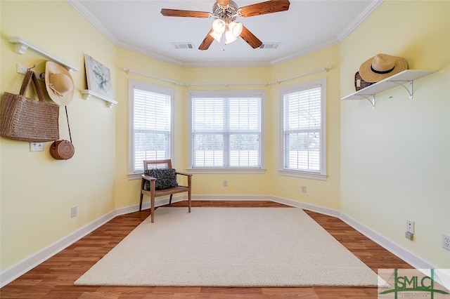 sitting room with hardwood / wood-style floors, ceiling fan, and crown molding