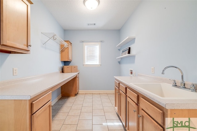 laundry room featuring cabinets, sink, washer hookup, a textured ceiling, and light tile patterned flooring