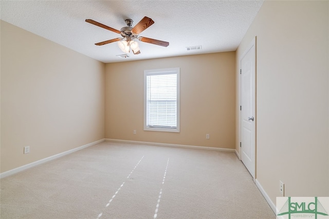 carpeted spare room featuring a textured ceiling and ceiling fan