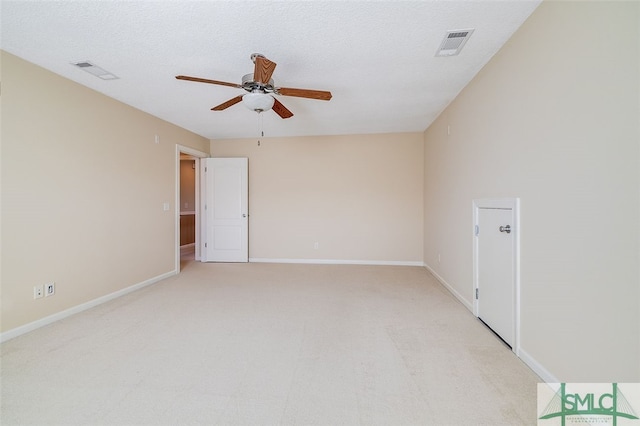 carpeted spare room with ceiling fan and a textured ceiling