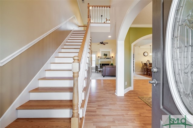 entrance foyer featuring light hardwood / wood-style flooring, ceiling fan, and crown molding