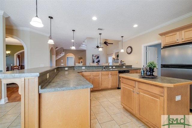 kitchen with ceiling fan, a center island, stainless steel appliances, and light brown cabinets