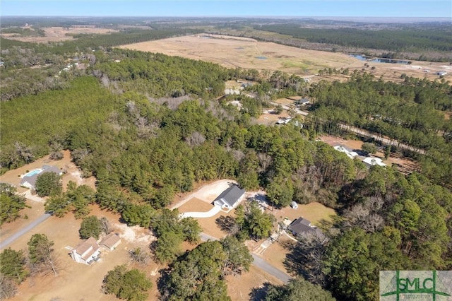 birds eye view of property featuring a forest view