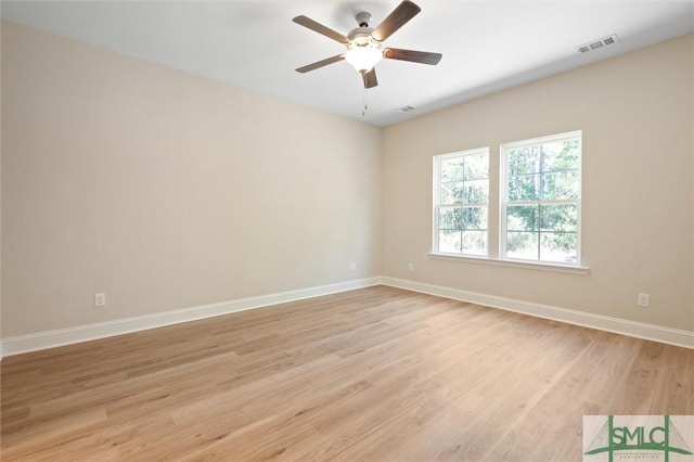 spare room featuring ceiling fan, light wood-type flooring, visible vents, and baseboards