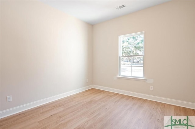 spare room with visible vents, light wood-style flooring, and baseboards