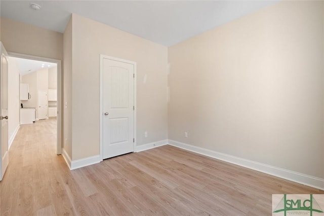 unfurnished bedroom with light wood-type flooring and baseboards