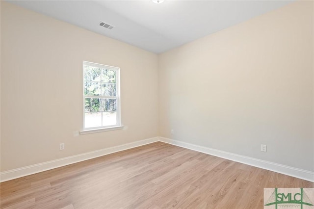 empty room featuring visible vents, light wood-style flooring, and baseboards