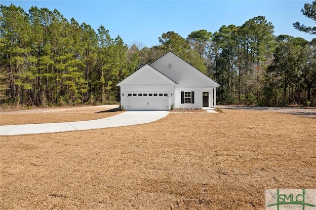 view of front of property with a front lawn, concrete driveway, and an attached garage