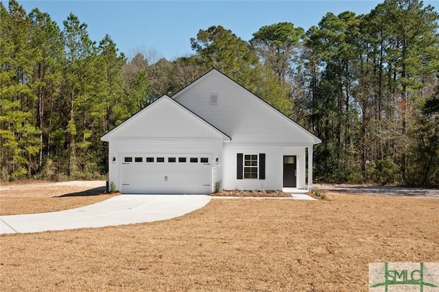 view of front facade featuring an attached garage, a view of trees, and concrete driveway