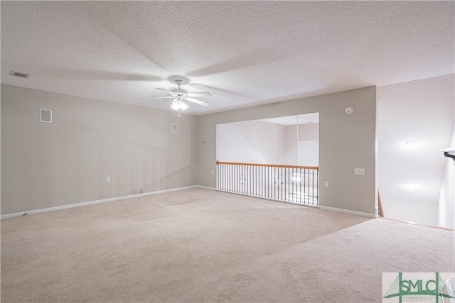 unfurnished room with ceiling fan, light colored carpet, and a textured ceiling