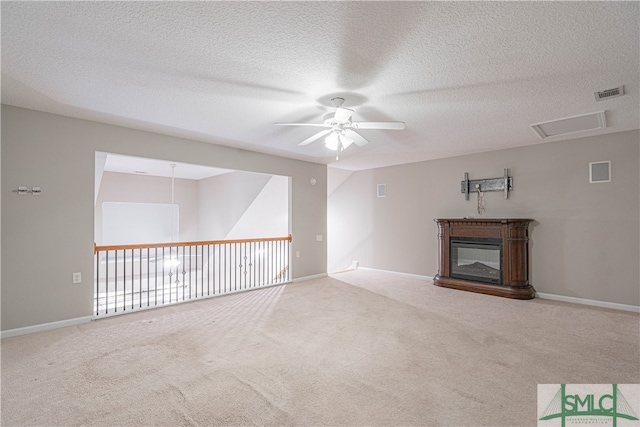 unfurnished living room featuring a textured ceiling, ceiling fan, and carpet flooring