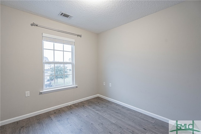 unfurnished room featuring hardwood / wood-style floors and a textured ceiling