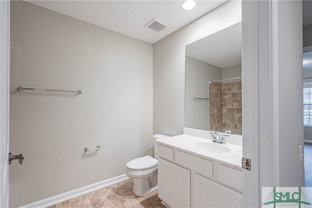 bathroom featuring tile patterned floors, vanity, toilet, and a textured ceiling