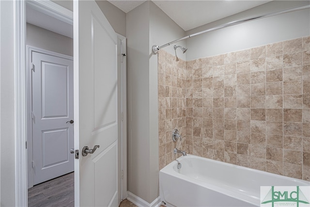 bathroom with hardwood / wood-style floors and tiled shower / bath combo