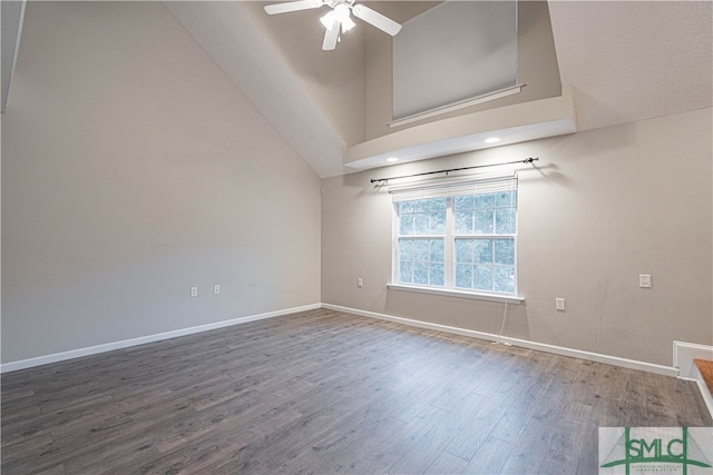 unfurnished room featuring dark hardwood / wood-style flooring, a towering ceiling, and ceiling fan