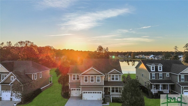 view of front of home featuring a lawn, a garage, and a water view