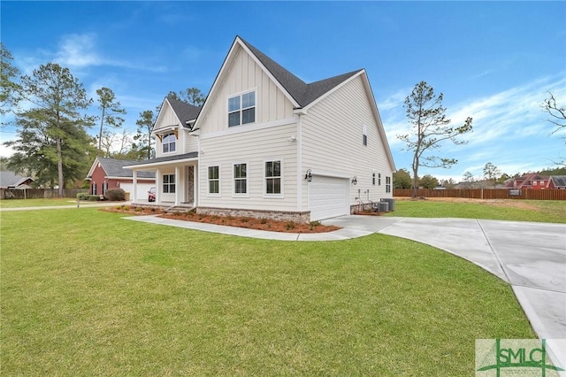 view of front of house featuring a garage, cooling unit, and a front lawn