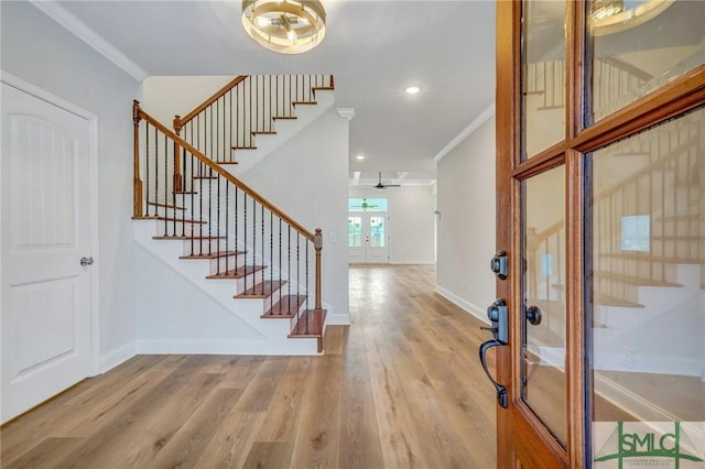 entrance foyer with light wood-type flooring, french doors, ceiling fan, and ornamental molding