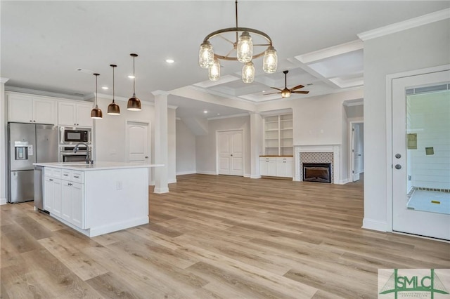 kitchen with stainless steel appliances, ornamental molding, recessed lighting, ceiling fan, and light countertops