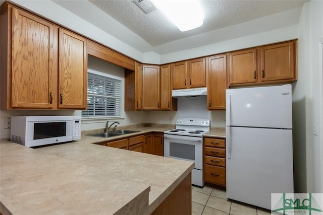 kitchen with white appliances, sink, light tile patterned floors, a textured ceiling, and kitchen peninsula