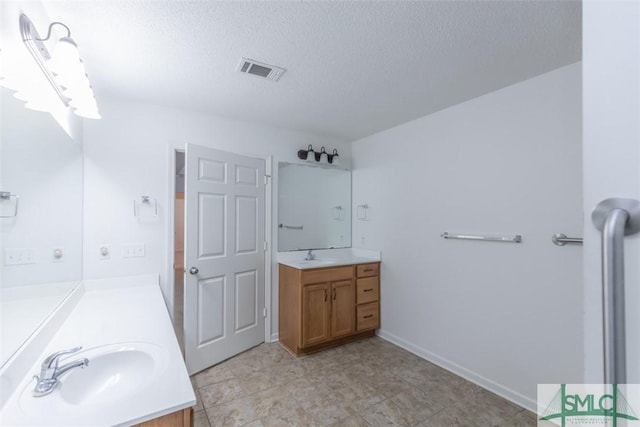 bathroom with vanity and a textured ceiling