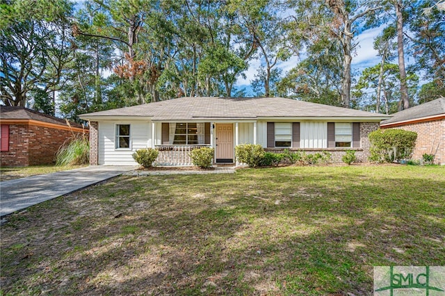 ranch-style home featuring covered porch and a front yard