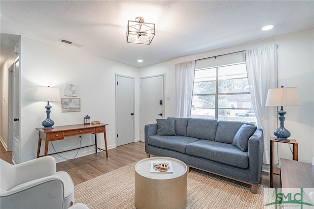 living room featuring a textured ceiling and light hardwood / wood-style floors