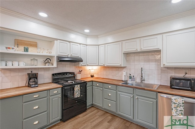 kitchen featuring sink, white cabinetry, butcher block counters, and black appliances