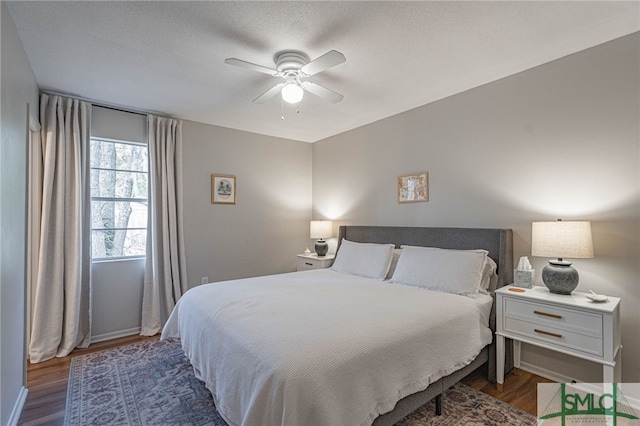 bedroom featuring ceiling fan, dark hardwood / wood-style floors, and a textured ceiling