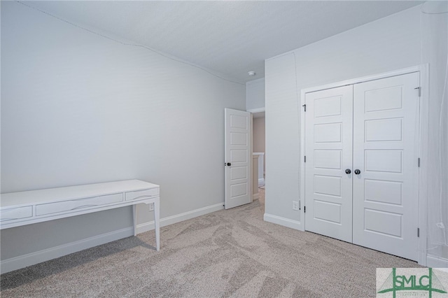 unfurnished bedroom featuring a closet and light colored carpet