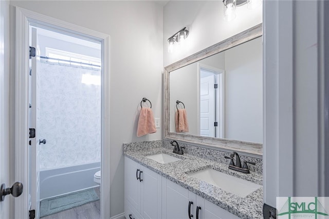 full bathroom featuring wood-type flooring, vanity, bathing tub / shower combination, and toilet