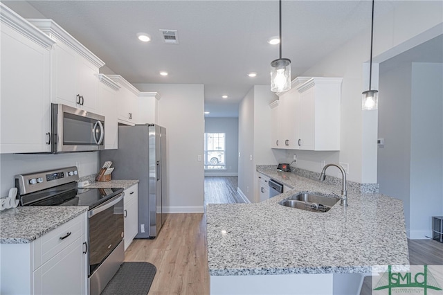 kitchen with sink, stainless steel appliances, light hardwood / wood-style flooring, decorative light fixtures, and white cabinets