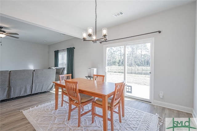 dining area featuring ceiling fan with notable chandelier and light wood-type flooring